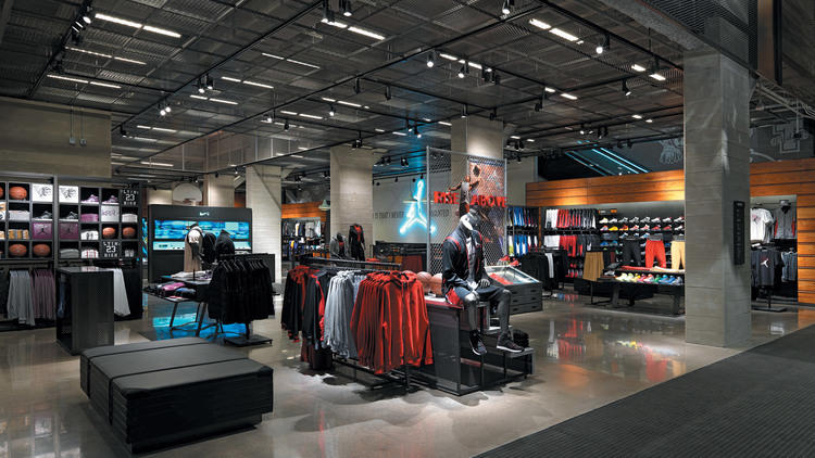 Inside a Nike store: apparel rails, a wall of footwear and a Jordan brand display under track lighting
